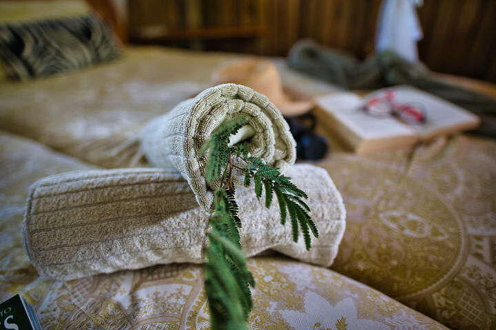 Two single beds against each other with towels rolled as decoration on top at the Mosetlha Bush Camp